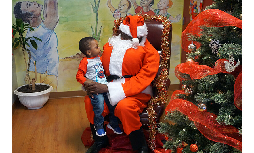 CHELC Santa Visit 12-16-2022 Boy in shark shirt looking at Santa for web