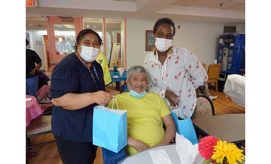 Extended Care Adopt-a-Resident Day 5-15-2024 Christiana Agbozo and Julienne Van-Nooten with man in yellow for web