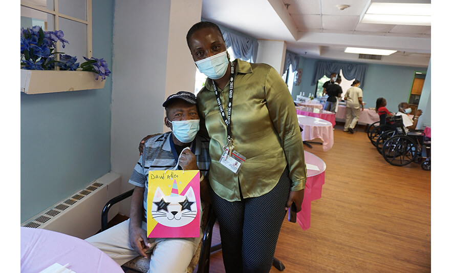 Extended Care Adopt-A-Resident Day 5-17-2023 Julienne Van-Nooten giving gift to David Allen for web